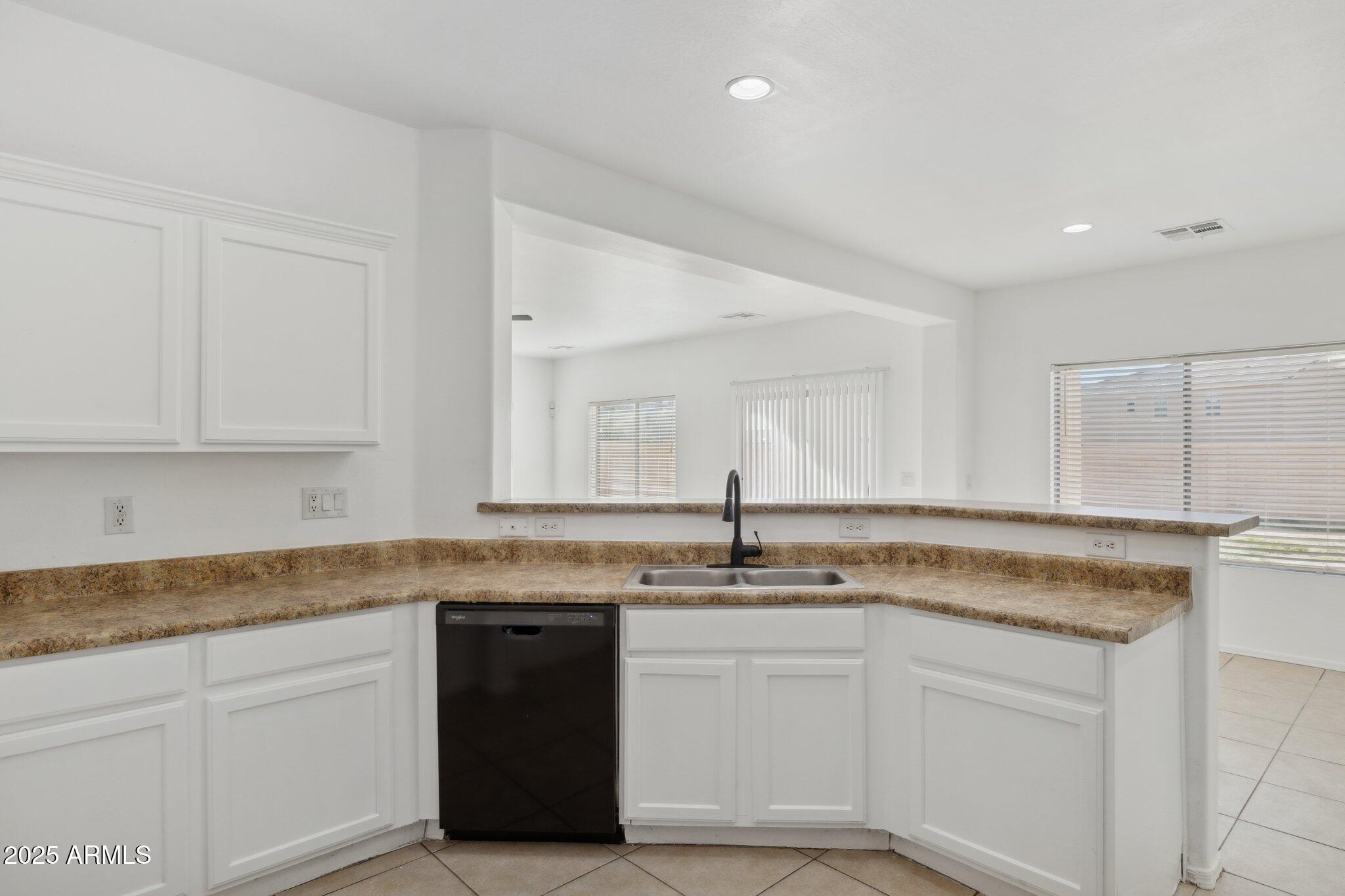 9951 West Bloch Road Tolleson, AZ 85353 - Photo 6 of 33 a kitchen with granite countertop cabinets sink and white stainless steel appliances