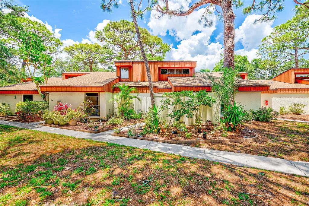 2064 Sunset Point Road, Unit 73 Clearwater, FL 33765 - Photo 1 of 58 a backyard of a house with yard and outdoor seating