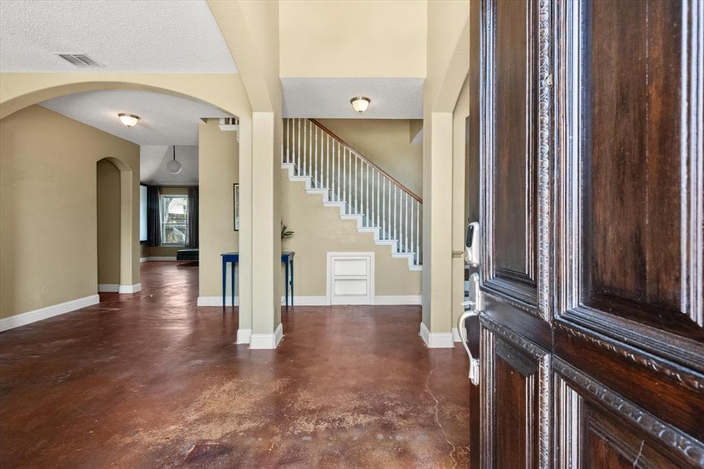 1305 Liverpool Lane Mansfield, TX 76063 - Photo 39 of 40 The property features a carved wooden entry door, an open floor plan with archways, and durable hard flooring