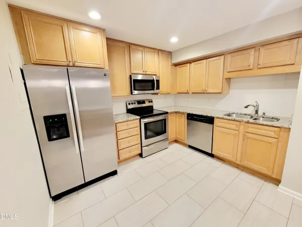 a kitchen with stainless steel appliances a refrigerator sink and microwave
