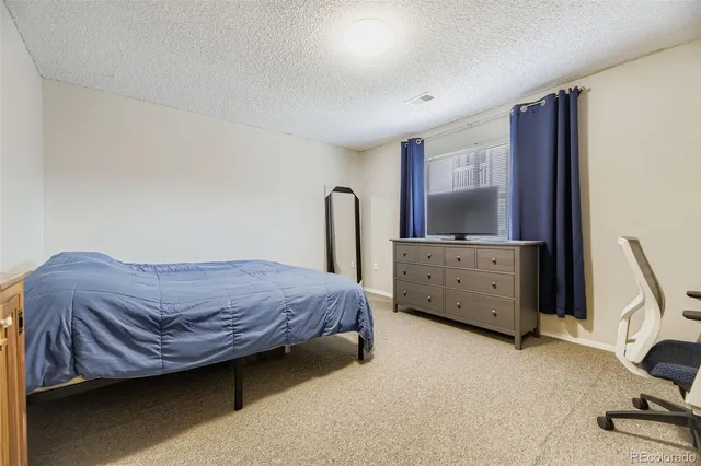 a spacious bedroom with a bed and a window