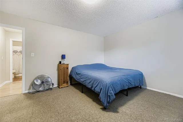 a bedroom with a bed and a chair in it