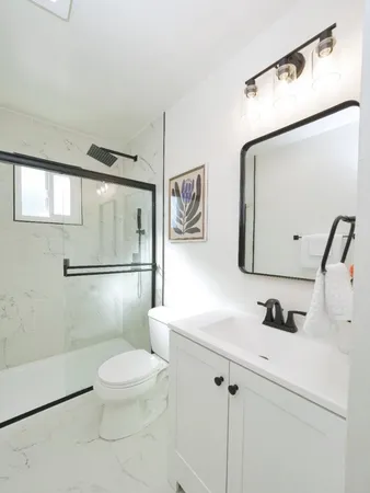 a bathroom with a sink a toilet and shower