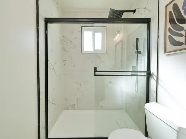 a bathroom with a toilet and a shower