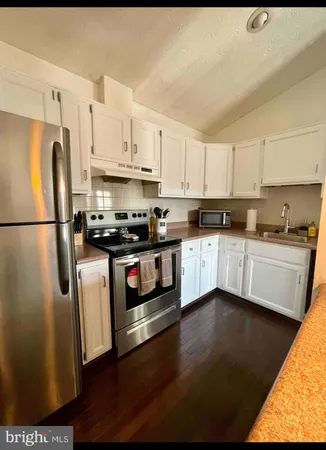 a kitchen with stainless steel appliances a refrigerator a sink a stove a microwave and cabinets