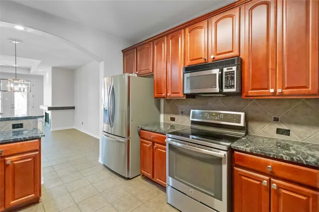 a kitchen with stainless steel appliances granite countertop wooden cabinets a sink and dishwasher