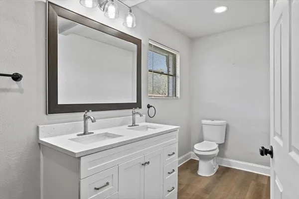 a bathroom with a toilet sink and mirror