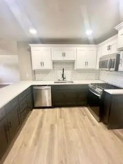 a large kitchen with granite countertop a sink and cabinets
