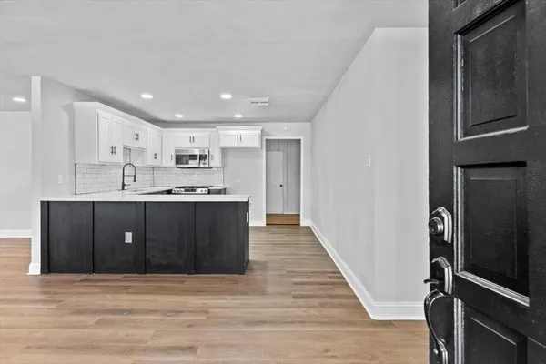 a view of kitchen with stainless steel appliances granite countertop a refrigerator and a sink