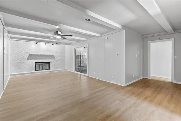 a view of an empty room with a fireplace and a window