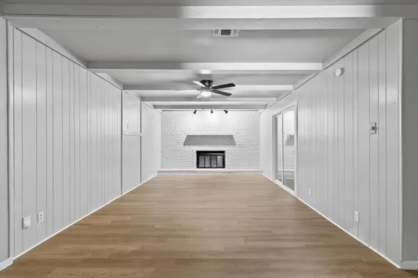 a view of an empty room with a fireplace and a window