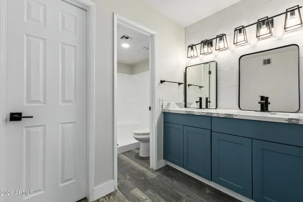 a bathroom with a double vanity sink a toilet and a mirror