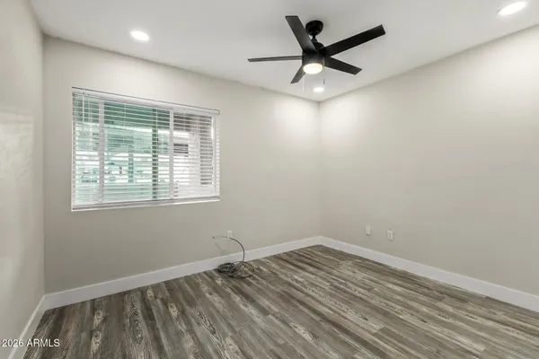 an empty room with a window and ceiling fan