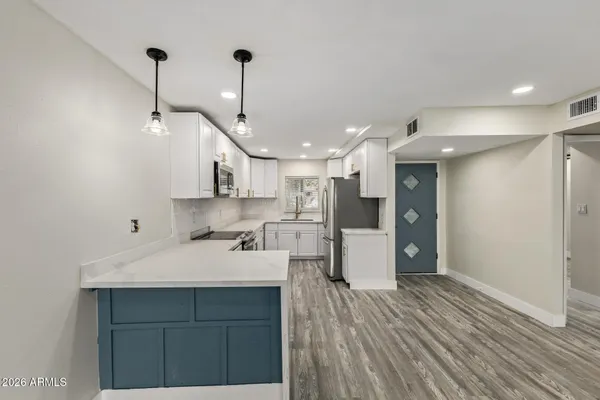 a kitchen with kitchen island a sink stainless steel appliances and a counter top space