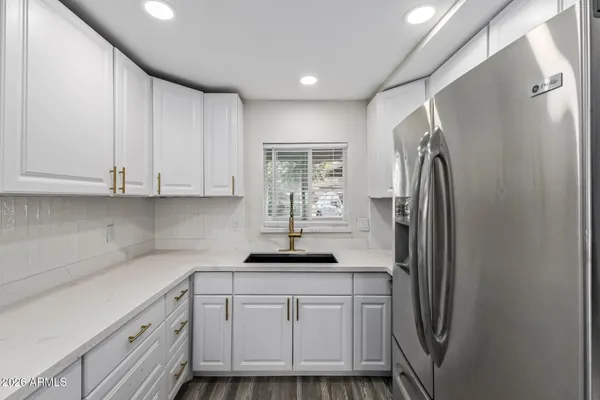 a kitchen with stainless steel appliances granite countertop a refrigerator and a sink