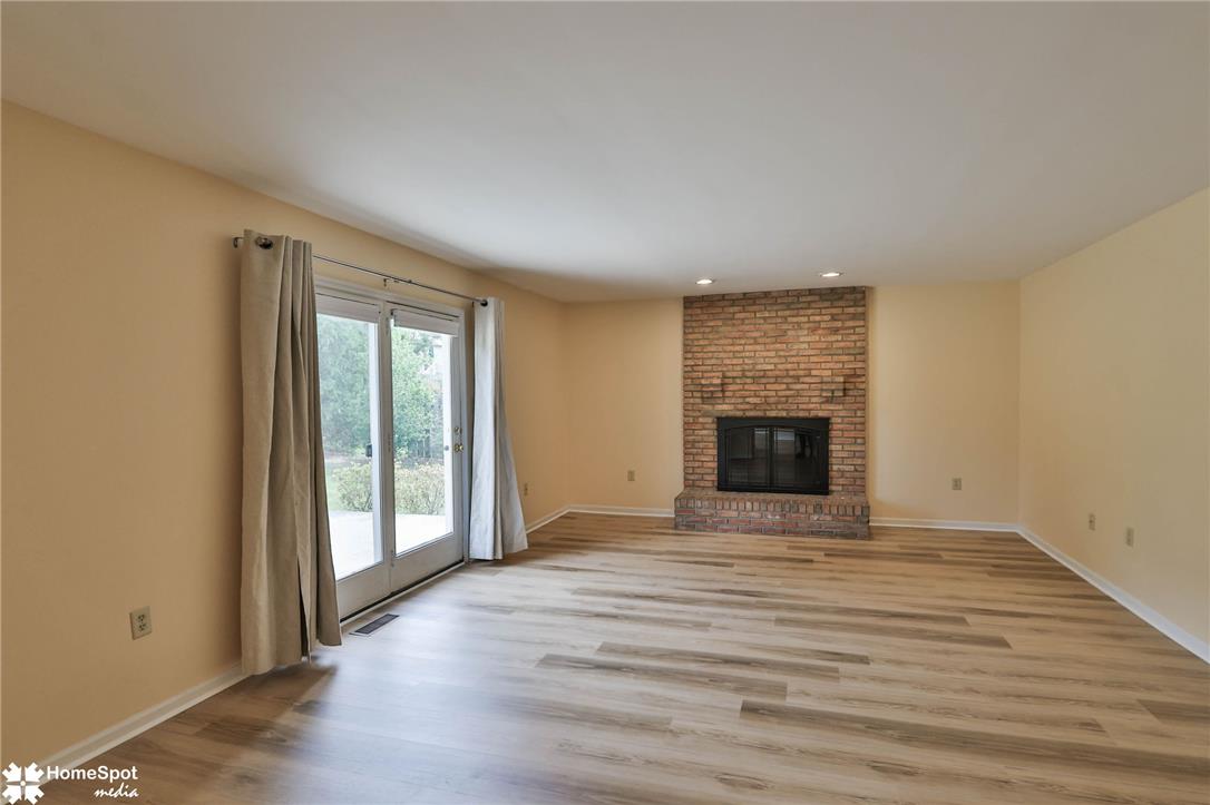 4059 Wedgewood Road Allentown, PA 18104 - Photo 24 of 72 Wood flooring and a classic brick fireplace anchor this airy living space with sliding glass doors.