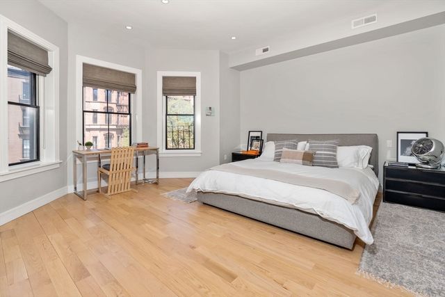 a bedroom with a bed and a large window