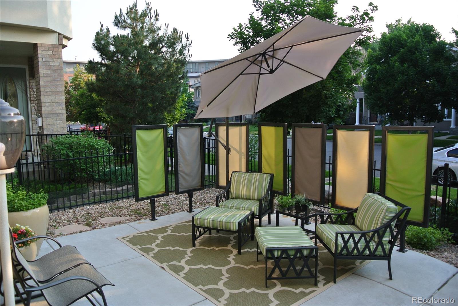 244 South Monroe Street Denver, CO 80209 - Photo 2 of 35 a view of a patio with a dining table and chairs under an umbrella