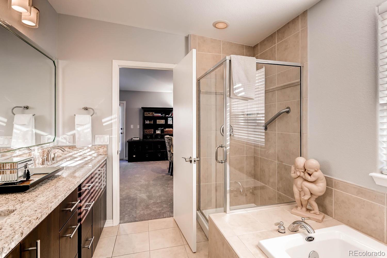 244 South Monroe Street Denver, CO 80209 - Photo 24 of 35 a bathroom with a granite countertop sink a mirror and shower