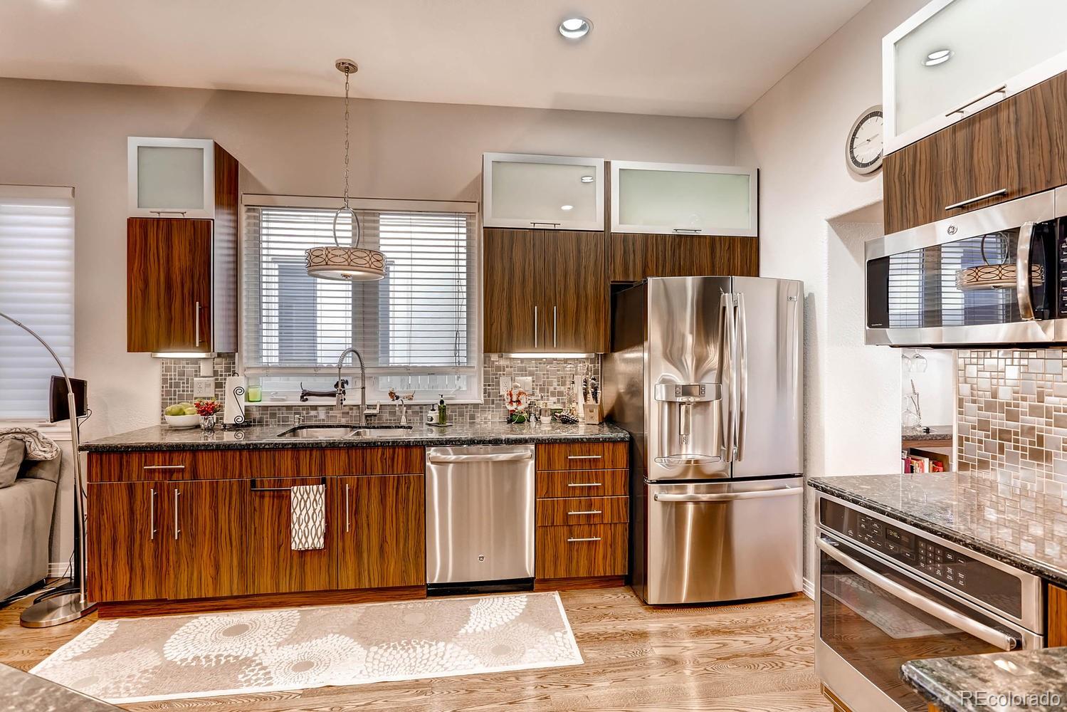 244 South Monroe Street Denver, CO 80209 - Photo 7 of 35 a kitchen with granite countertop a refrigerator and a stove top oven