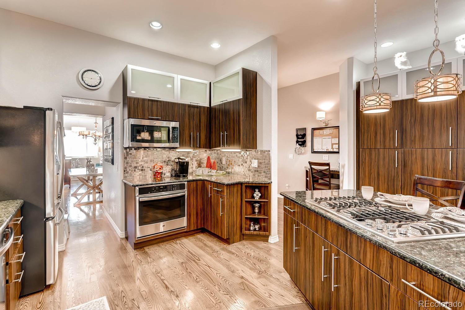 244 South Monroe Street Denver, CO 80209 - Photo 9 of 35 a kitchen with stainless steel appliances kitchen island granite countertop a refrigerator stove and oven