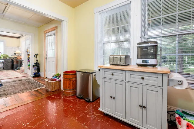 a view of a kitchen with fridge and windows
