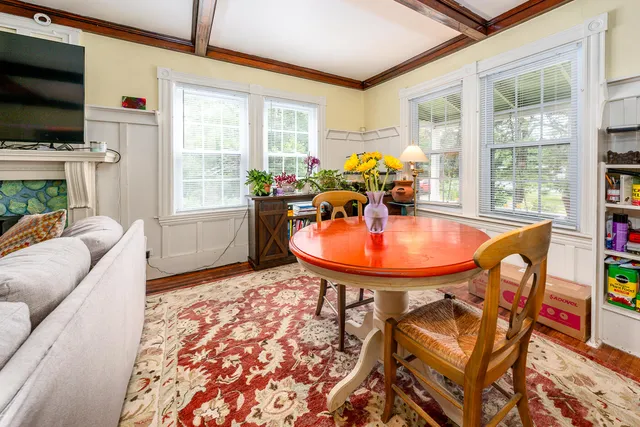 a dining room with furniture and a floor to ceiling window