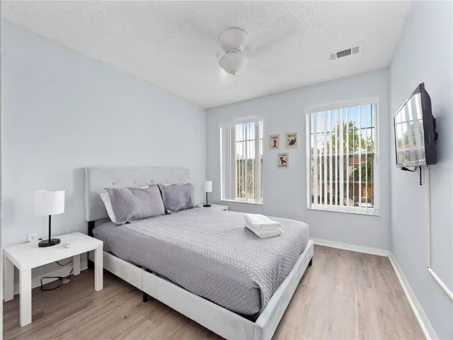 a bedroom with a large bed wooden floor and window