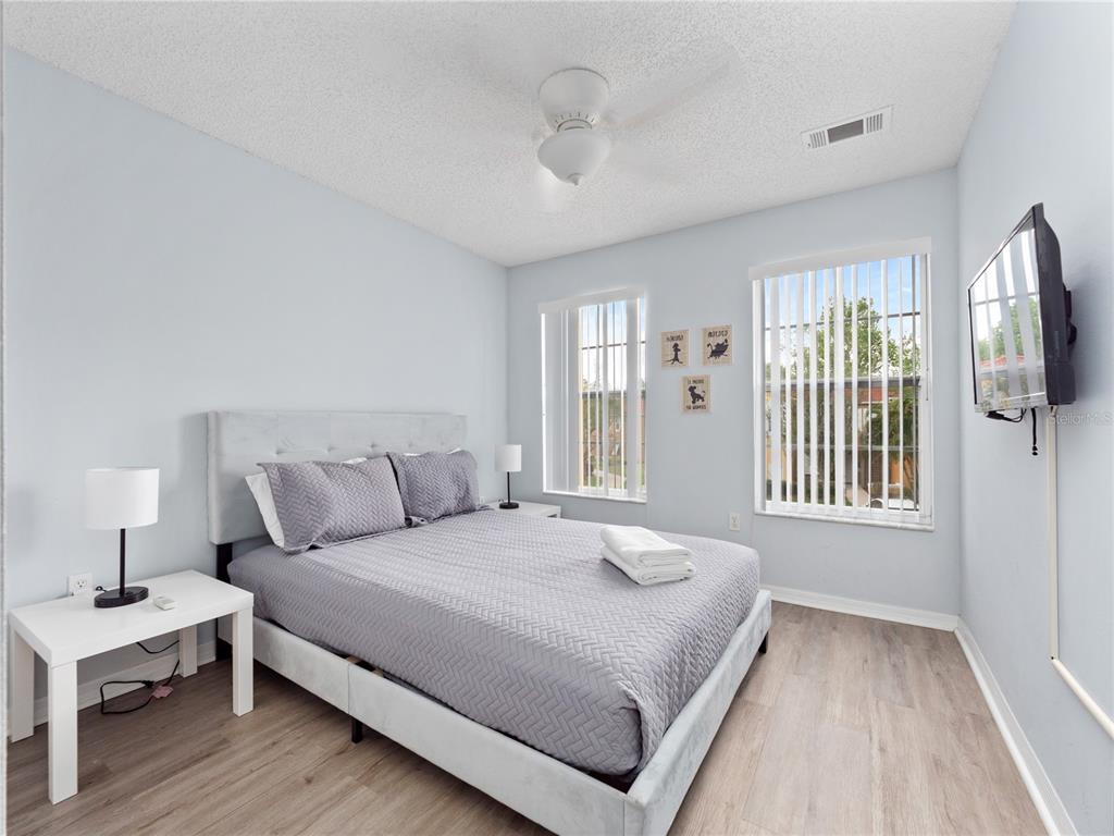 8517 Crystal Cove Loop Kissimmee, FL 34747 - Photo 12 of 20 a bedroom with a large bed wooden floor and window