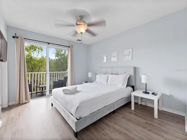 a large white bed sitting in a bedroom next to a window