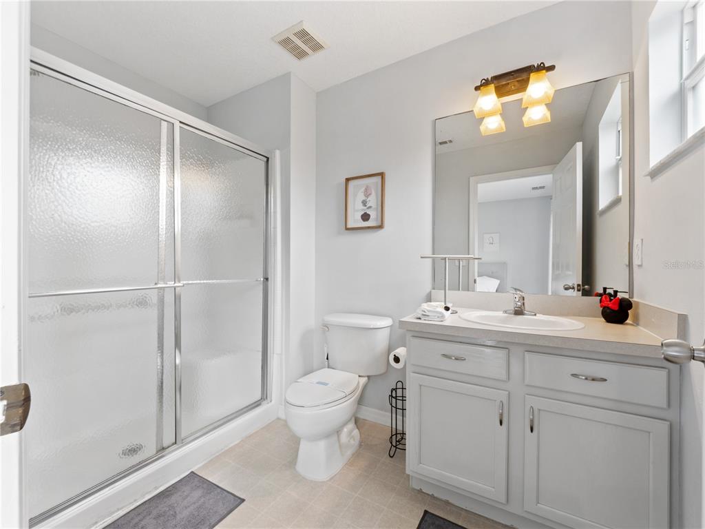 8517 Crystal Cove Loop Kissimmee, FL 34747 - Photo 17 of 20 a bathroom with a toilet sink vanity and mirror