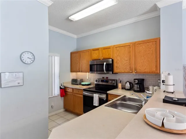 a kitchen with stainless steel appliances a sink a stove a microwave a refrigerator and cabinets