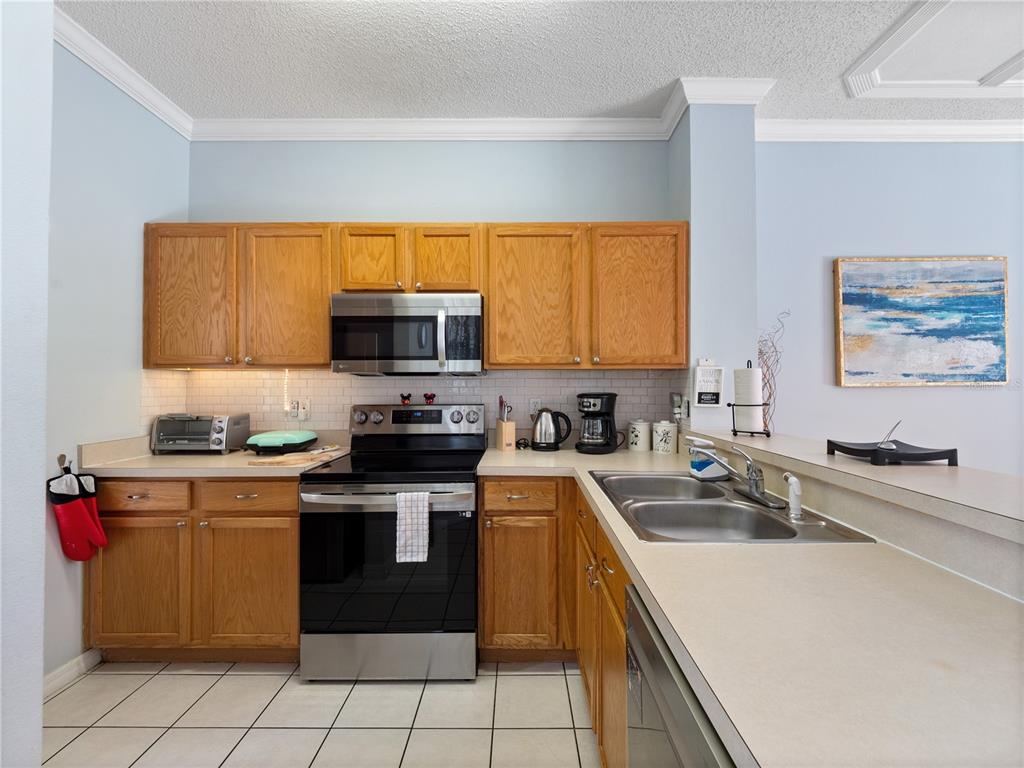 8517 Crystal Cove Loop Kissimmee, FL 34747 - Photo 9 of 20 a kitchen with a sink a stove and microwave