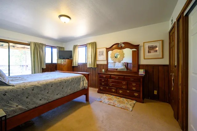 a bedroom with a bed and dresser with mirror