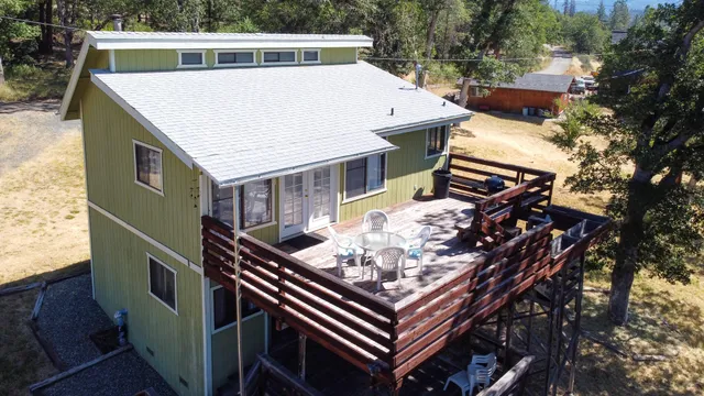 an aerial view of a house with a yard and large trees