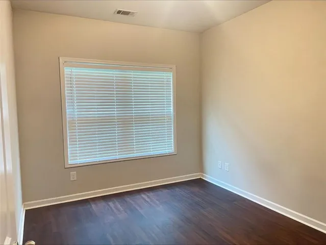 an empty room with wooden floor and a window