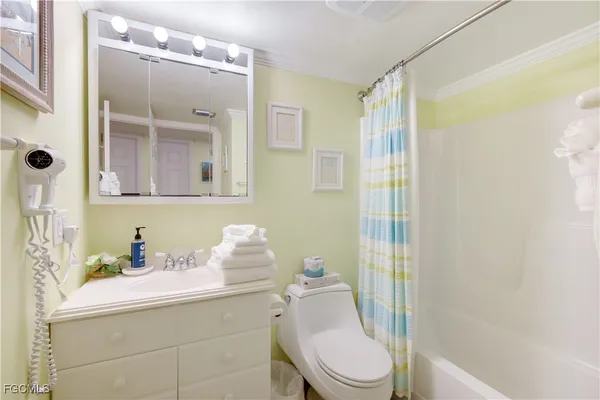 a bathroom with a sink a toilet a mirror and shower
