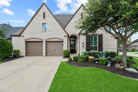 a front view of a house with a garden and plants
