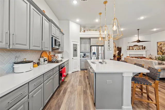 a kitchen that has a lot of cabinets and wooden floor