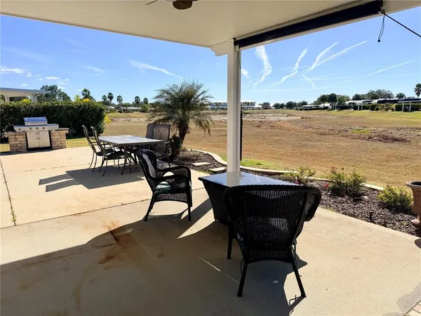 a view of a ocean with a table and chairs in the patio