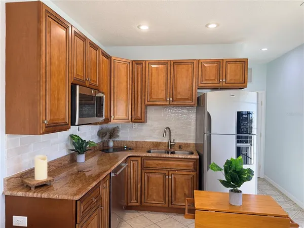 a kitchen with stainless steel appliances granite countertop a refrigerator sink and cabinets
