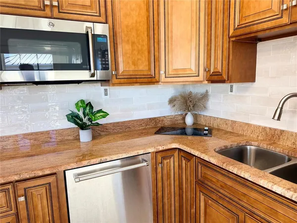 a kitchen with stainless steel appliances granite countertop a sink a granite counter tops and a wooden cabinets