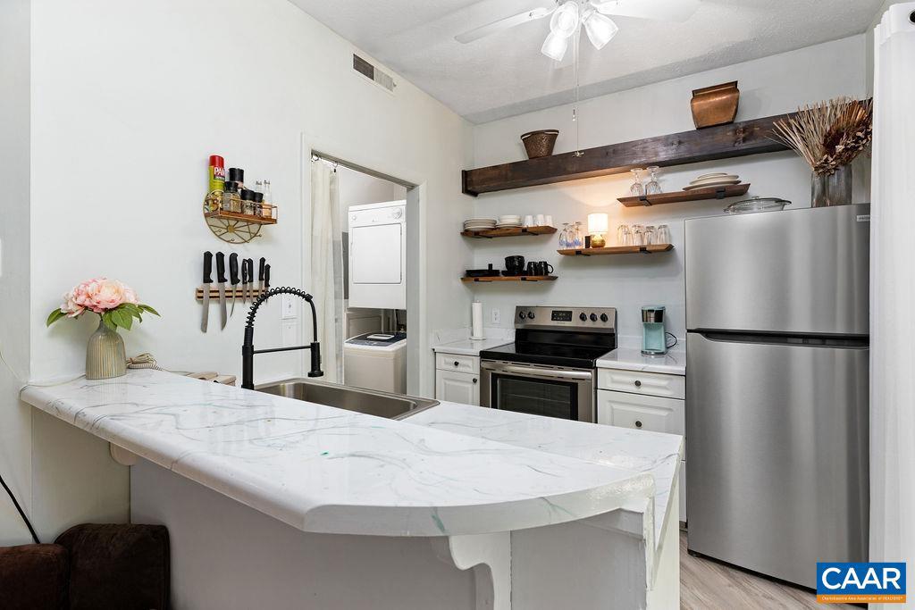 490 Three Ridges Roseland, VA 22967 - Photo 15 of 27 a kitchen with stainless steel appliances granite countertop a refrigerator a stove and a sink with wooden floor