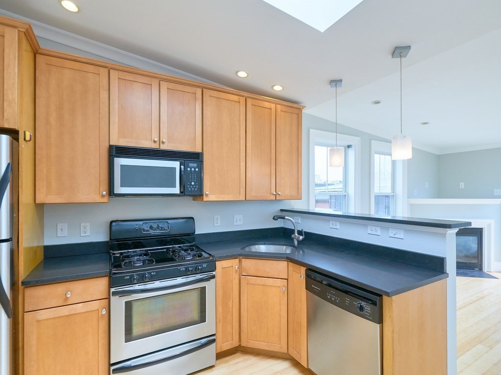 3 Leeds Street, Unit 3 Boston, MA 02127 - Photo 2 of 27 a kitchen with stainless steel appliances granite countertop a sink a stove and a microwave