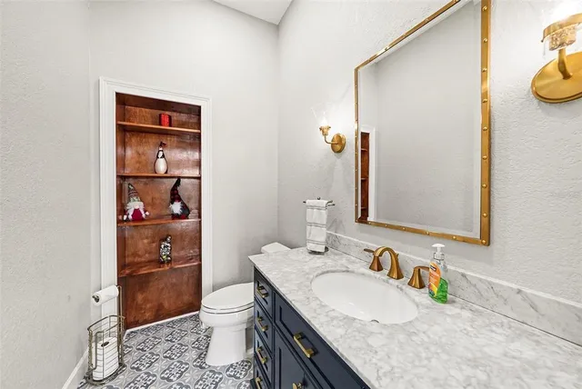 a bathroom with a granite countertop sink a toilet and a mirror