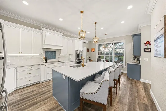 a kitchen with a table chairs refrigerator and cabinets