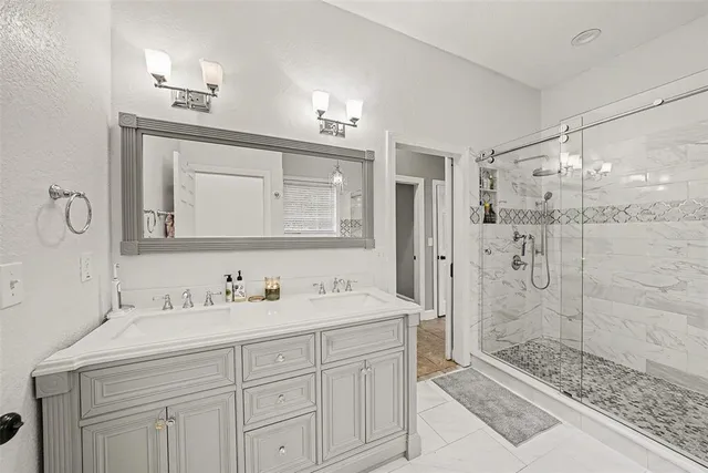 a bathroom with a shower sink and mirror