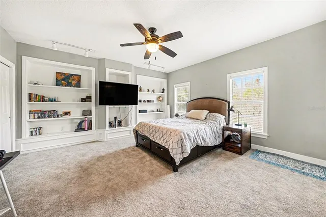 a spacious bedroom with a bed and a flat screen tv