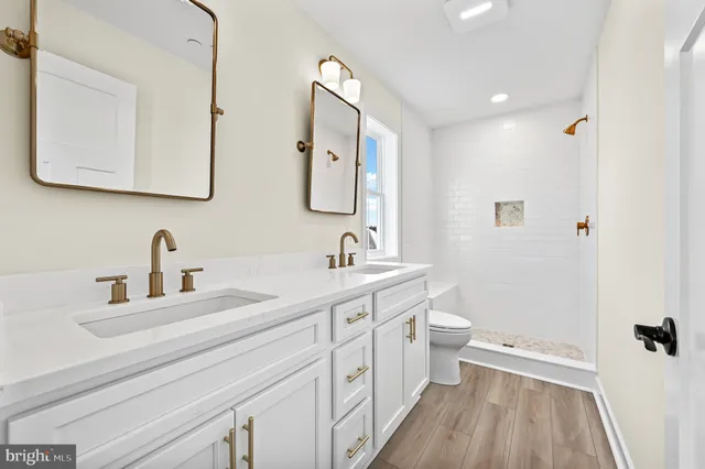 a bathroom with a double vanity sink a toilet and a mirror