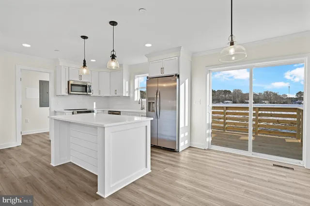 a kitchen with stainless steel appliances cabinets a wooden floor and a sink